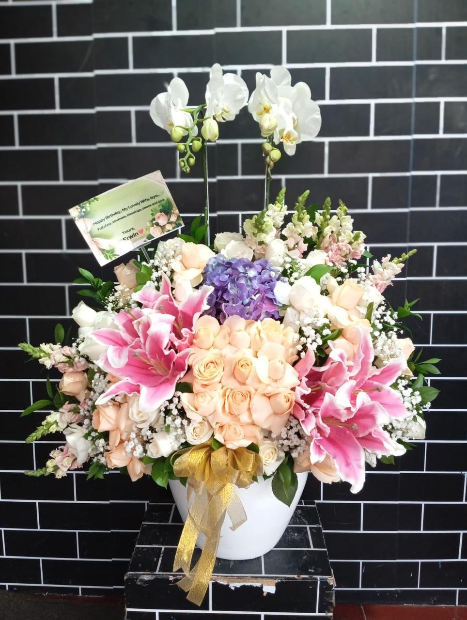 Standing flower happy 48th anniversary Sanggar Sarana Baja dari PT Jotun Indonesia mawar pink merah dan lily 2 tier
